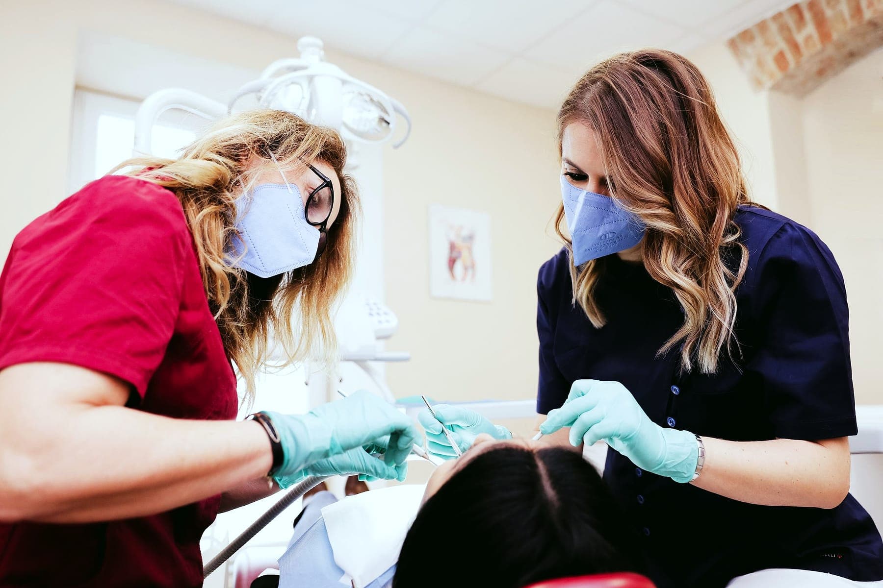Due odontoiatre di Curedent attorno alla poltrona, in una sala operativa luminosa