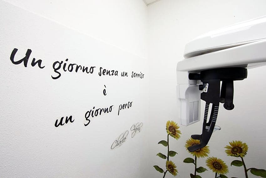 La parete con il motto «Un giorno senza un sorriso è un giorno perso» e l'apparecchio per le panoramiche