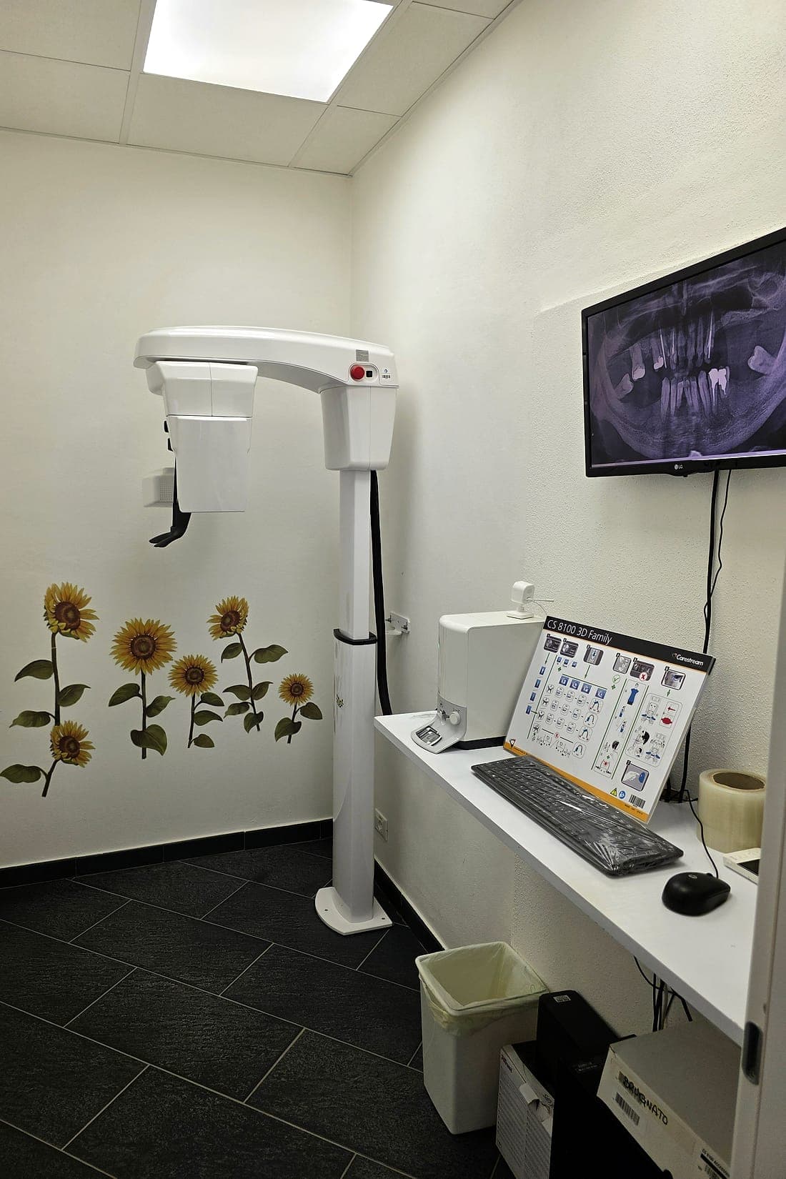 La stanza delle radiografie, con l'apparecchio per panoramiche e TAC e i girasoli sulla parete