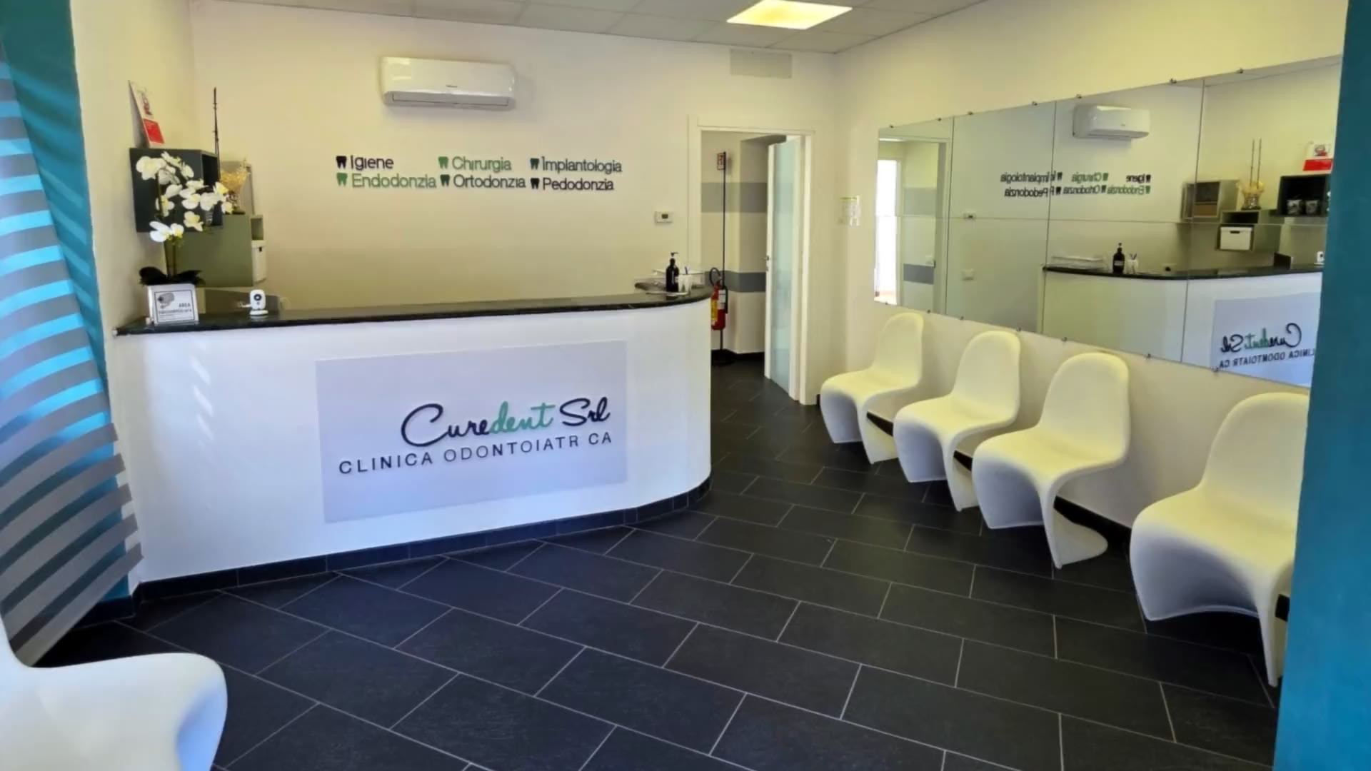 L'accoglienza di Curedent, con il bancone e le sedute bianche